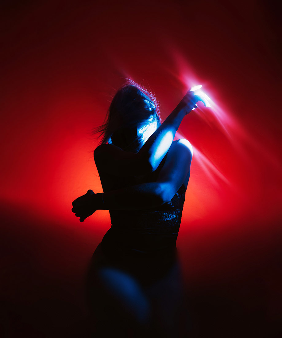 Self portrait with complementary red and blue color filters, raised arm and motion frozen by off-camera flash