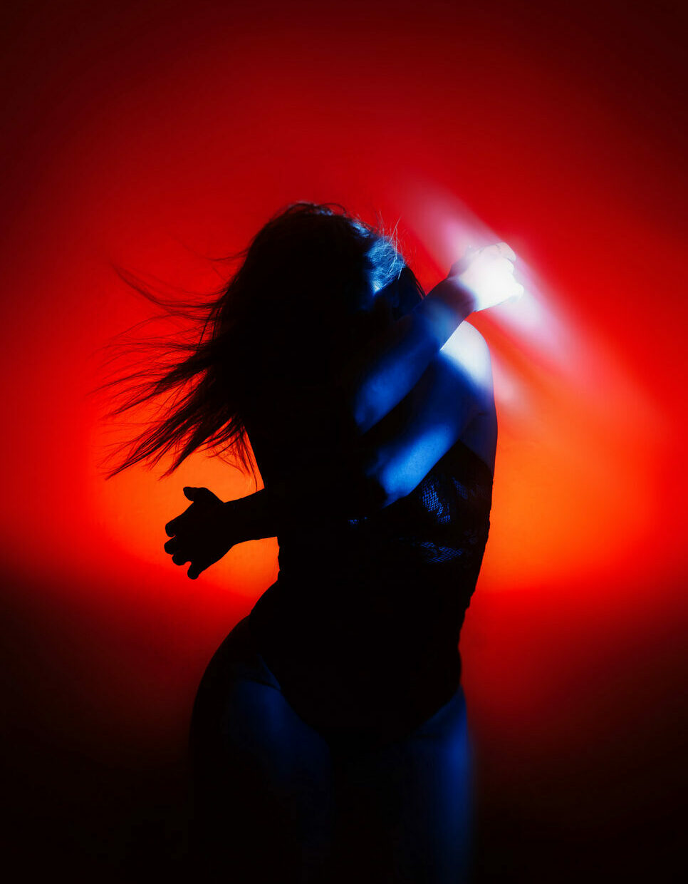 Dramatic self portrait with red and blue color filter flash and deep shadow contrast