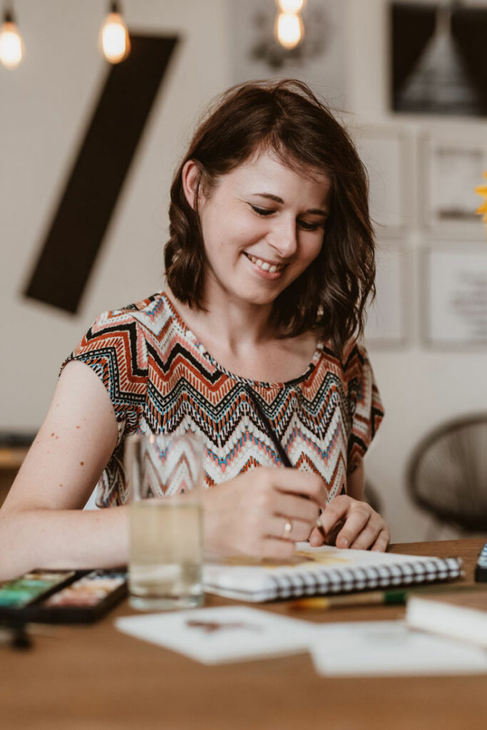 Modernes Businessportrait einer Illustratorin im Tageslicht beim malen, Businessfotos für Frauen