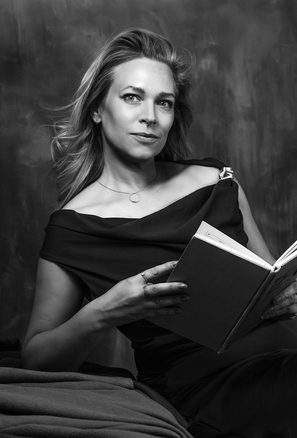 Schwarzweiss Portrait von der Fotografin Sabine Fischer mit einem Buch in den Händen