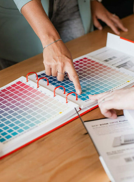 zwei finger zeigen auf ein buch mit farben