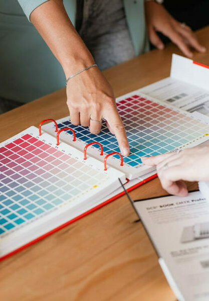 zwei finger zeigen auf ein buch mit farben