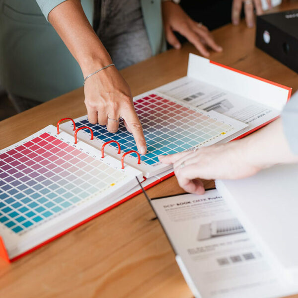 zwei finger zeigen auf ein buch mit farben