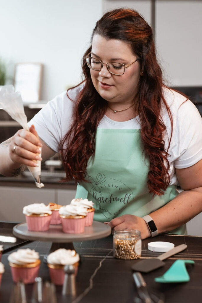 Ramona von Kleine Naschwelt – Personal Branding Portrait im Backstudio beim Dekorieren von Cupcakes