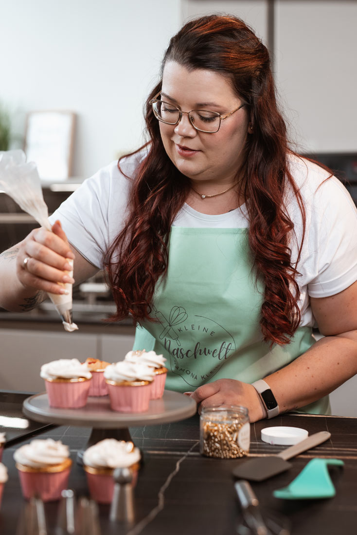 Ramona von Kleine Naschwelt – Personal Branding Portrait im Backstudio beim Dekorieren von Cupcakes