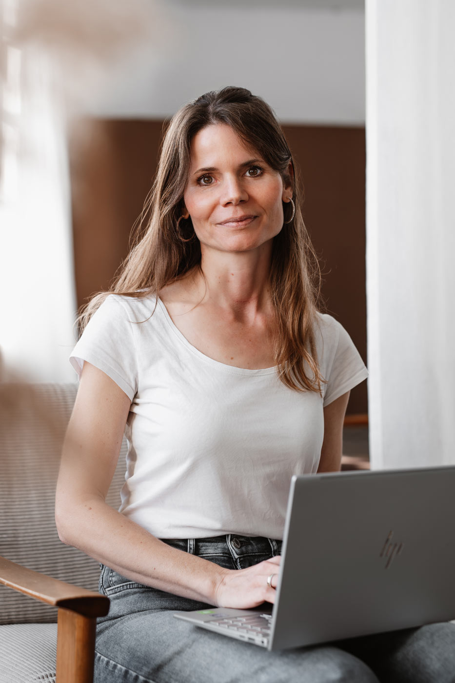 Authentisches Personal Branding Foto einer Entspannungspädagogin in entspannter Sitzhaltung am Laptop
