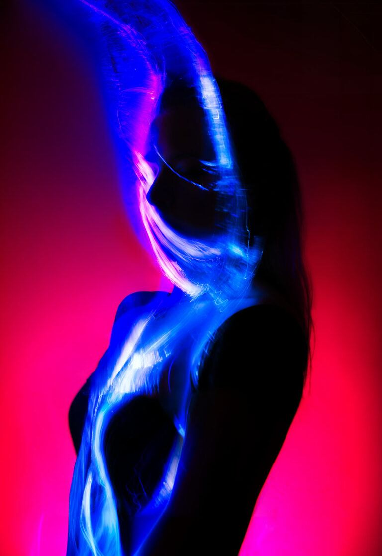 Blue and pink fiber optic light painting self-portrait with long exposure light trails