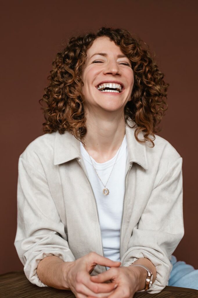 Personal Branding fotos einer lachenden Frau vor braunem Hintergrund
