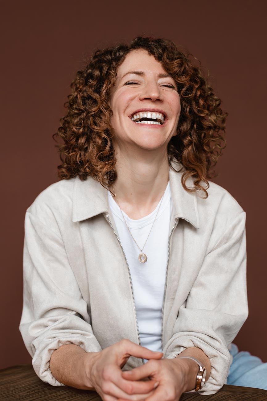 Personal Branding fotos einer lachenden Frau vor braunem Hintergrund