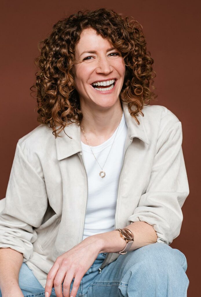 authentische Personal Branding fotos einer lachenden Frau vor braunem Hintergrund