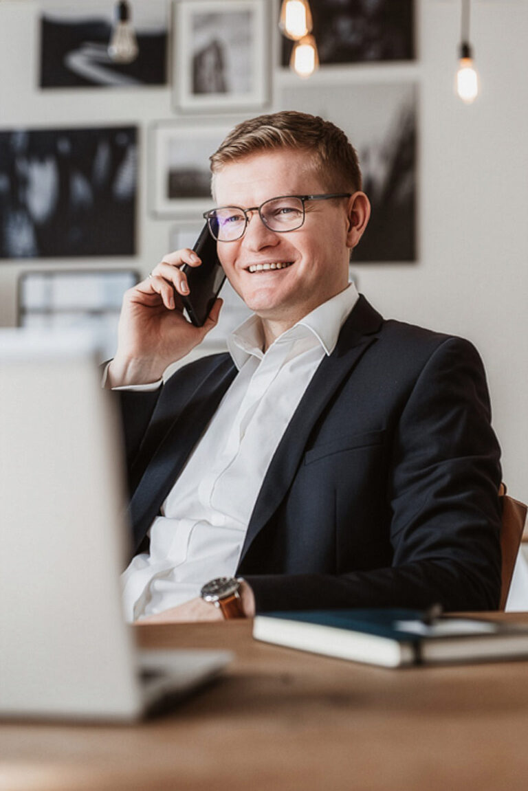 Personal Branding Portrait eines Unternehmers mit Laptop beim Telefonat
